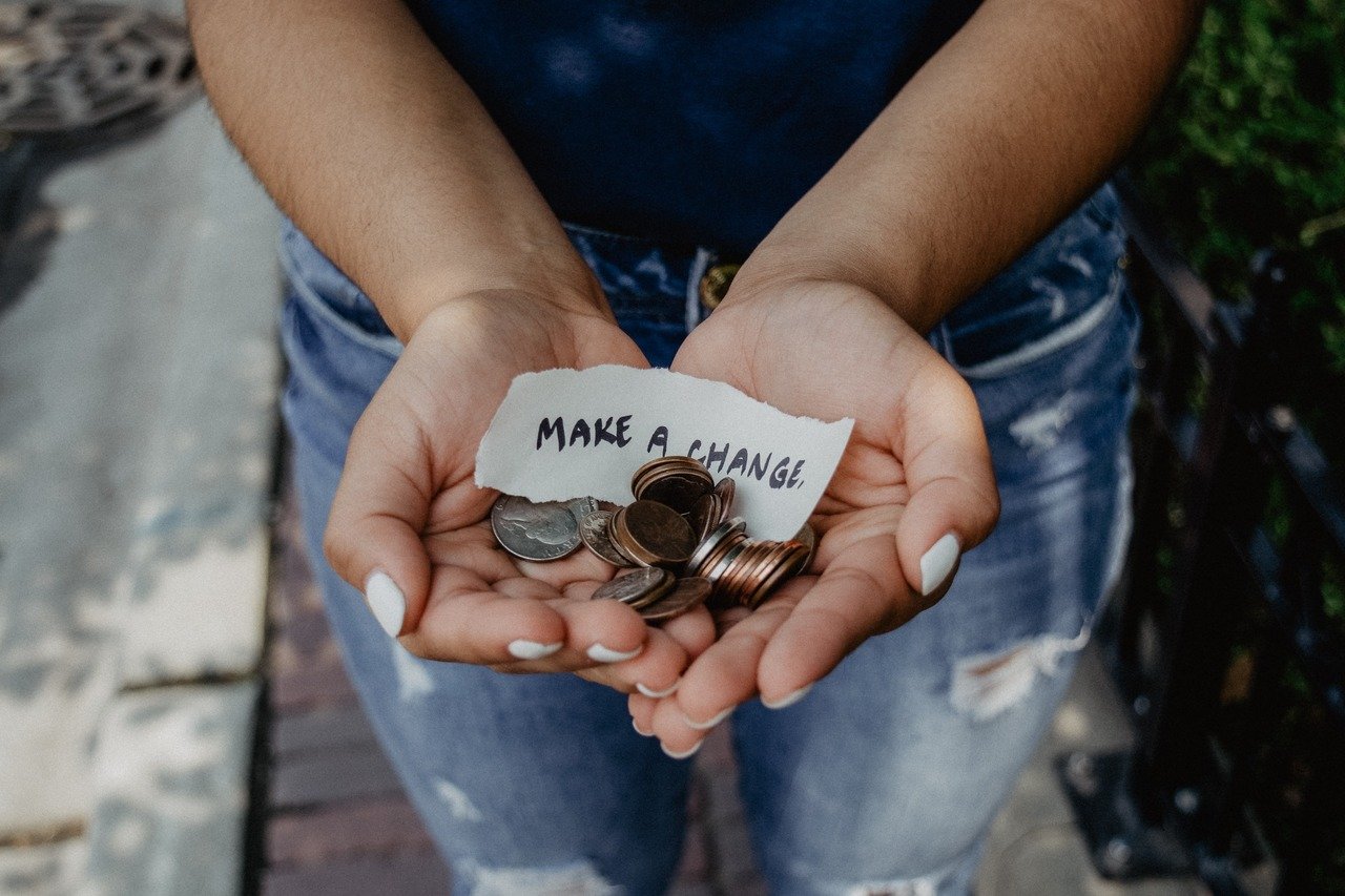 a palm of cash money with make a change handwriting