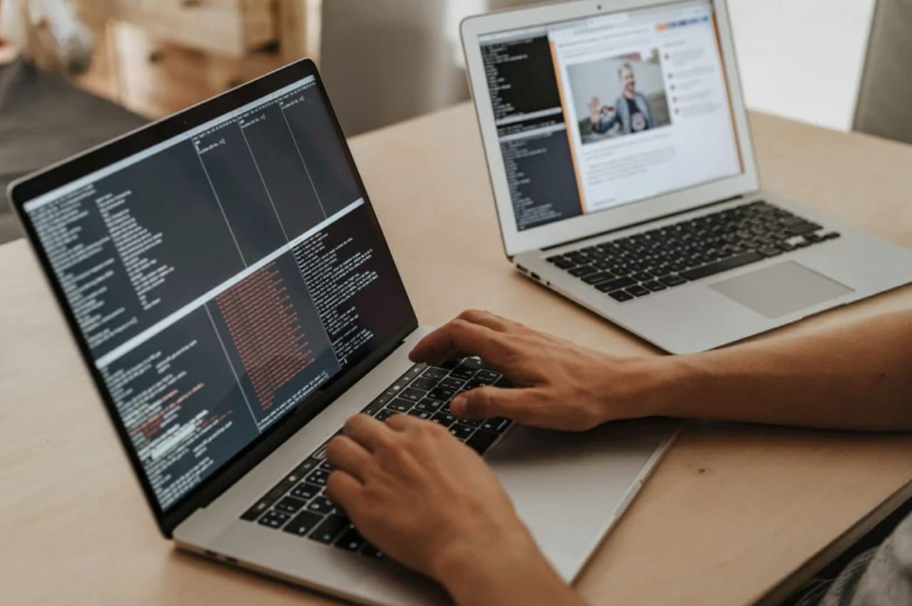 a picture of a man's hands working witha laptop coding and solving the website crash problems