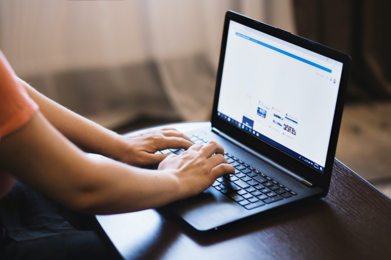 Person, die in ihrem Browser auf einem Laptop nach etwas sucht