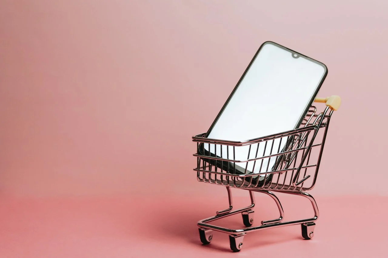 abandoned cart apps image with a pink background and a mobile phone in a cart