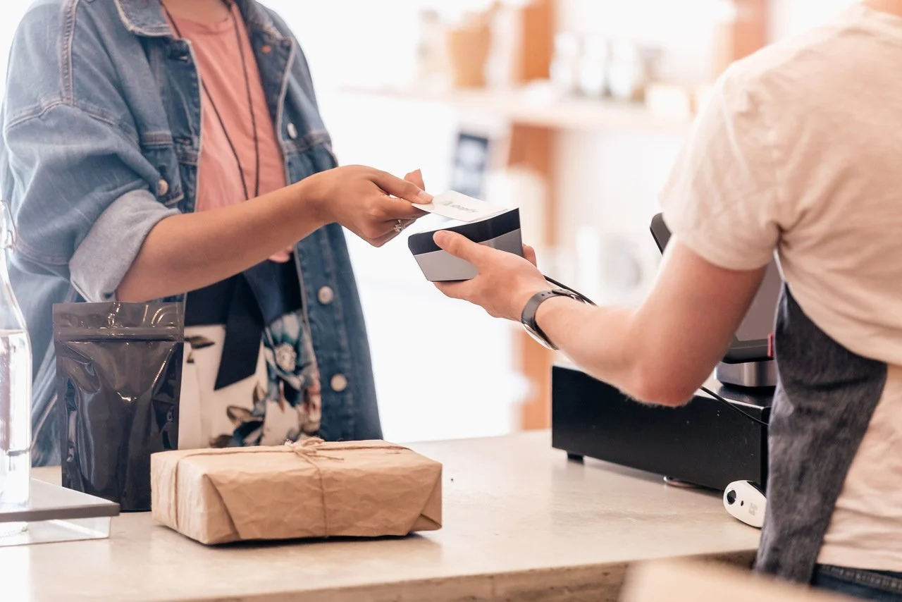 uma mulher pagando pelos produtos que comprou com cartão de crédito