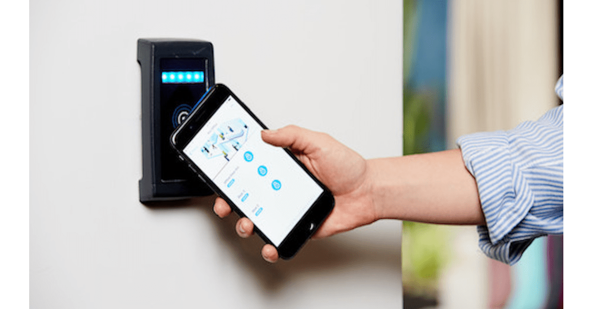 L'immagine di un dipendente che apre la porta di un ufficio con il proprio smartphone.