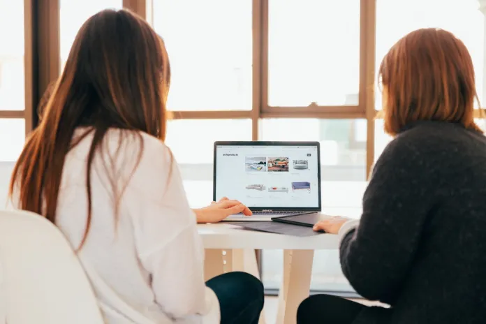 Un design grafic mai bun poate crește vertiginos vânzările de comerț electronic în 2022 1 two women talking while looking at laptop computer