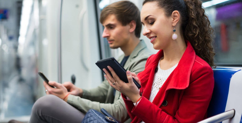 Para czytająca SMS-a w pociągu