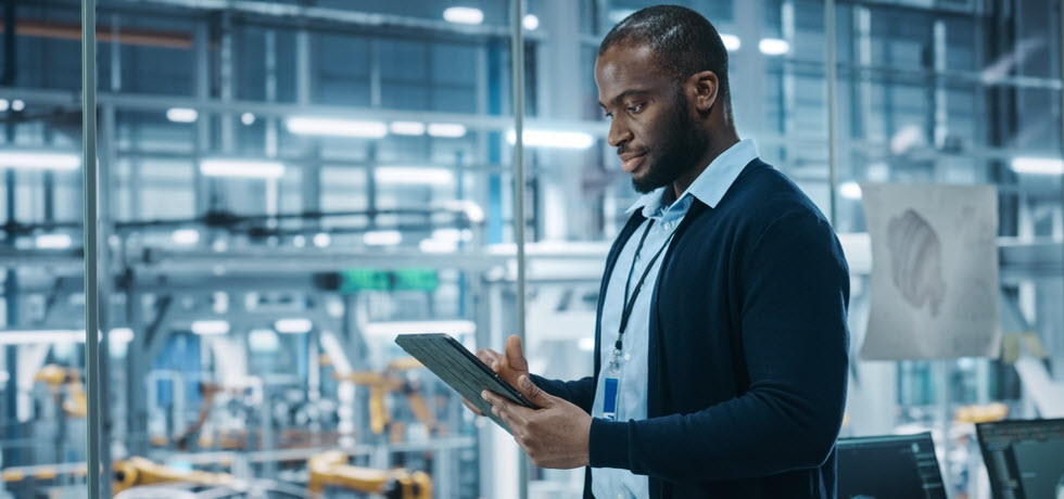 Um homem controlando mensagens de texto automatizadas no tablet