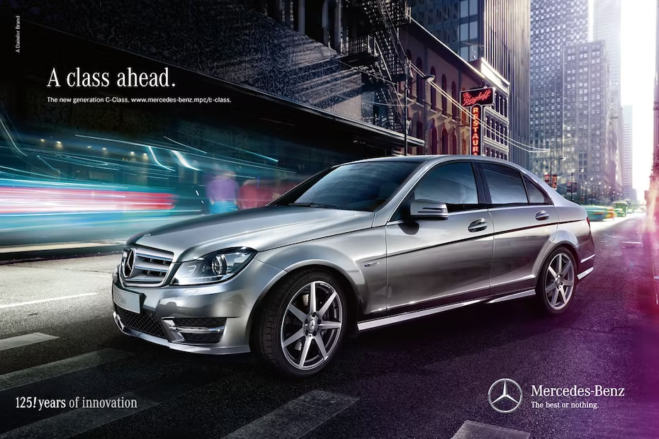 Mercedes-Benz Anzeige mit einem silbernen Auto in der Stadt und dem Schriftzug „Eine Klasse voraus“ darüber.