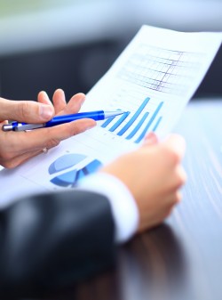 Image d'une main masculine pointant vers un document commercial