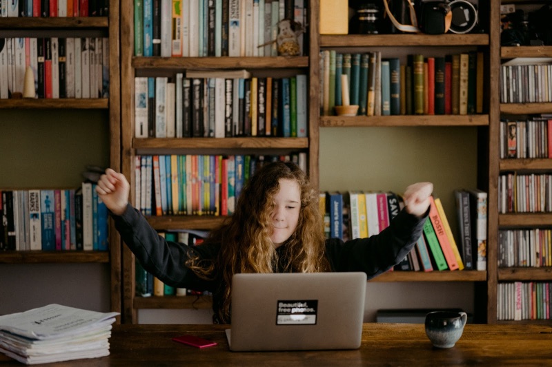 Orang yang merayakan di meja mereka melihat laptop mereka