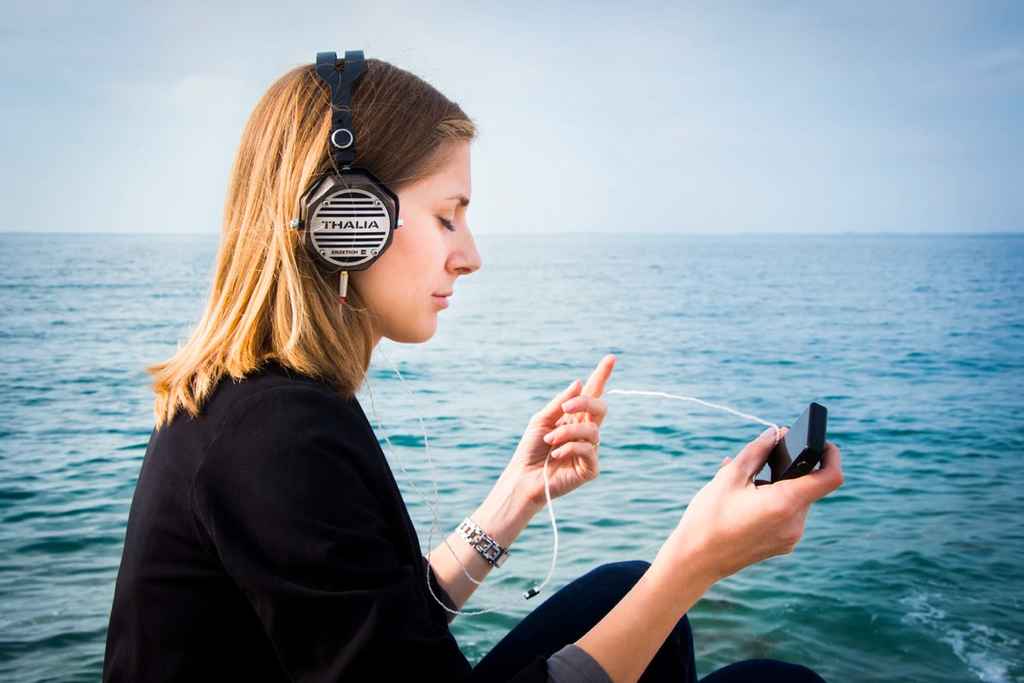 audiobooks | O femeie ascultă o carte audio lângă mare
