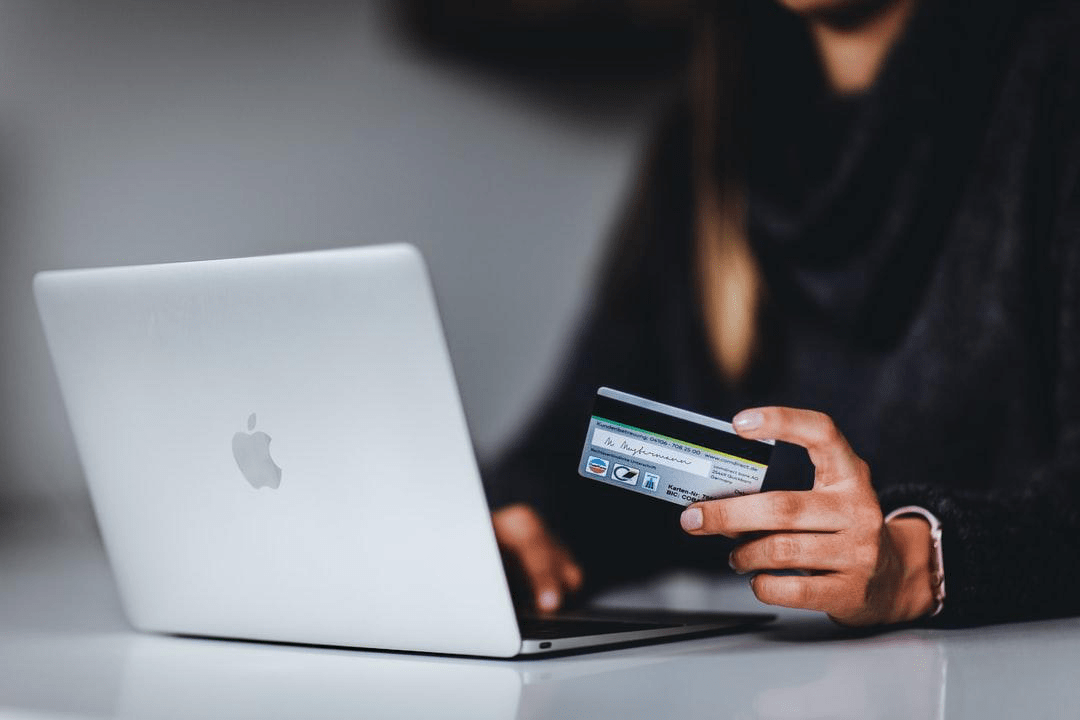 persona in possesso di carta con il computer portatile