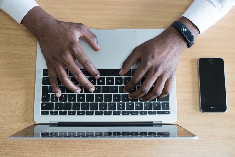 Aufnahme von oben einer Person, die auf ihrem Laptop tippt